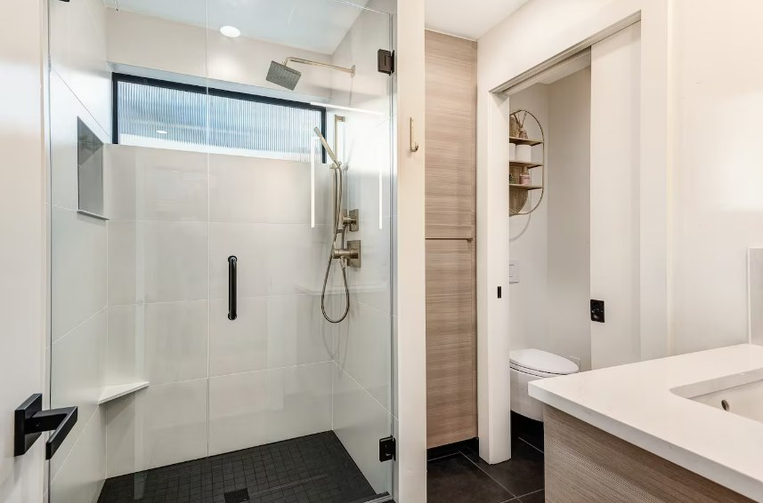 Remodeled bathroom with frameless glass shower and black fixtures